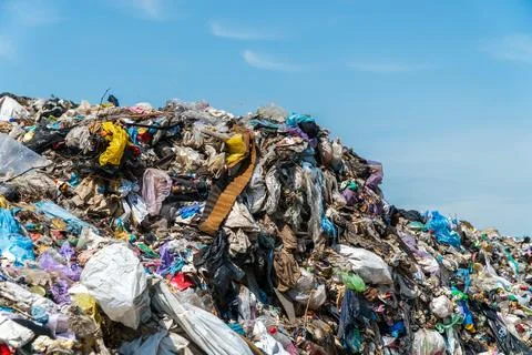 A massive mound of trash filled with plastic, fabric, and other debris is s.. Stock Photos