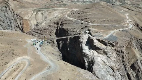Massive Mountain Gorge with Chicham Bridge Spanning Across Stock Footage 329332050