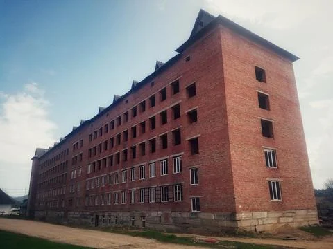 Massive Multi Storey Red Brick Building Under Construction Against Blue Sky Stock Photos