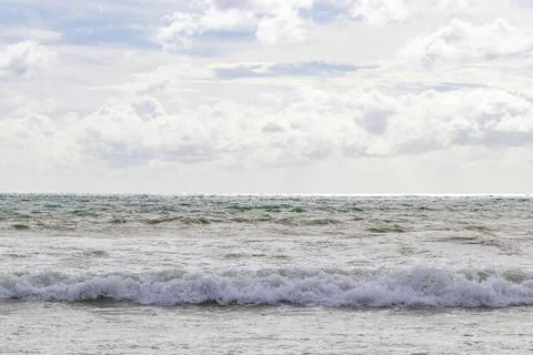 Massive paradise ocean waves beneath cloudy tropical blue coastal atmospher.. Stock-Fotos