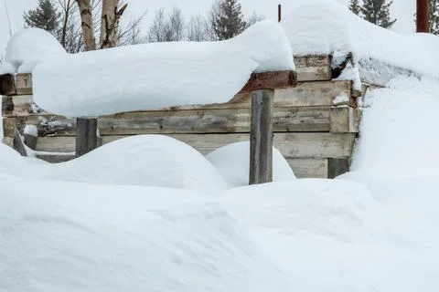 A massive pile of snow in front of a building, almost covering the windows. T Stock Photos