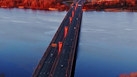 Massive Red Cable-Stayed Bridge Glows at Sunrise in Riga Over Daugava River Stock Footage 307910678
