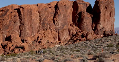 Massive red rock formation at head of Fire Wave trail-Distant hikers Stock Footage 237765656