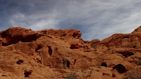 Massive red sandstone cliffs tower over the desert landscape Stock Footage 329560001