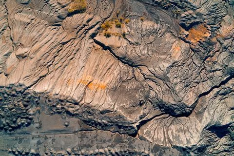 Massive sculpted mining waste mound. Aerial abstract of eroded industrial Stock Photos