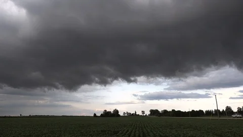 Massive severe thunderstorm and dangerous dark clouds rolling in over farm Stock Footage 92936237