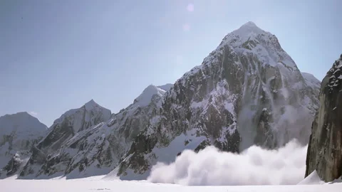 Massive snow avalanche sliding down a mountain peak Stock Footage 335105721