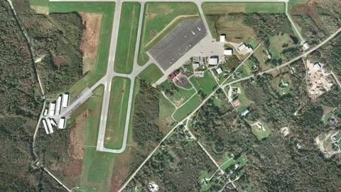 A massive spaceship passes over a small, regional airport Stock Footage 133680440