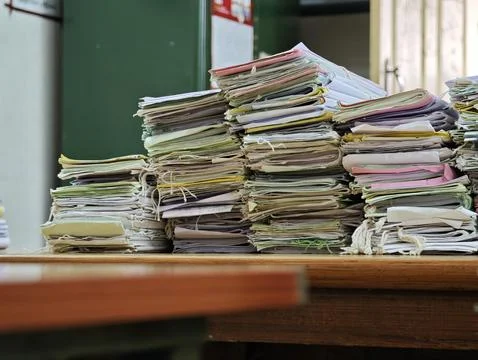 Massive stacks of old case files tied with strings sit on a wooden table in.. Foto stock