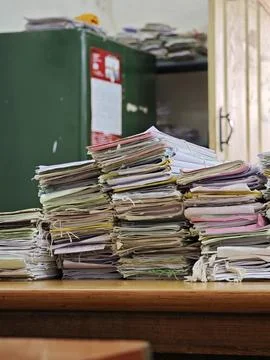 Massive stacks of old case files tied with strings sit on a wooden table in.. Foto stock