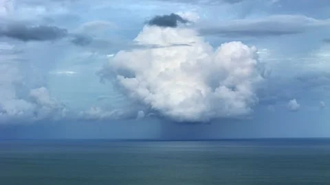 Massive storm cloud forming above calm sea horizon symbolizing power of nature Stock Footage 323483863