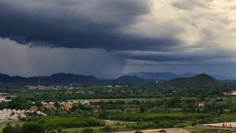 Massive storm cloud over mountain valley raising flood risk during tropical Stock Footage 314358223