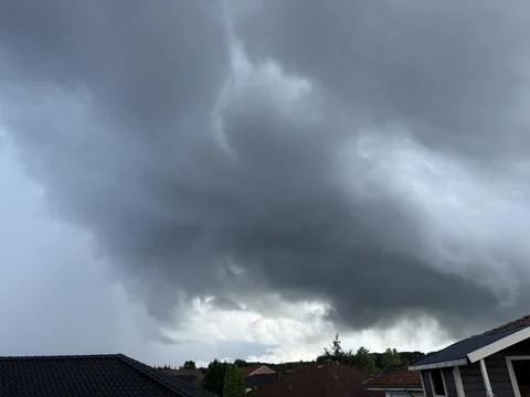 Massive storm clouds over rooftops in northern Germany dramatic weather and.. Foto stock