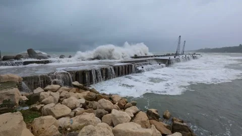 Massive storm waves crashing over a pier with seawater flooding the structure Stock Footage 318316837
