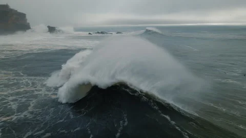Massive stormy waves crash at Nazare Portugal's famous coastline Stock Footage 321475189