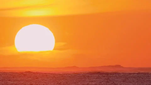 Massive Sun Dips into the Ocean Stock Footage 184257791
