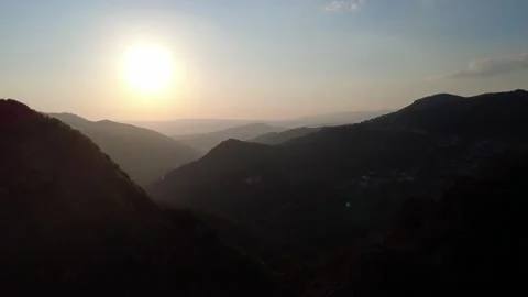 Massive sunset sphere visible beyond steep mountain walls inside deep gorge Video stock 325221172