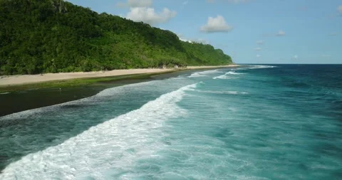 A massive wave crashes onto the sandy beach, merging with the horizon Stock Footage 270559761