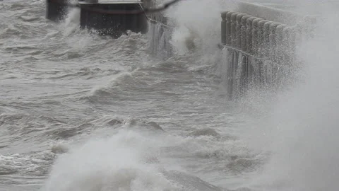 Massive waves breaking and crashing into shore in hurricane force wind storm. Stockbeeldmateriaal 147995625
