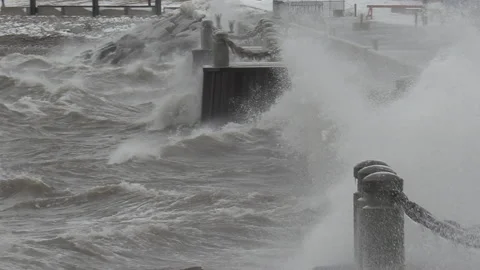 Massive waves breaking crashing into shore in wind storm Видео 147983656