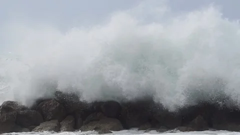 Massive waves over wavebreaker, slow motion Stock Footage 190588843
