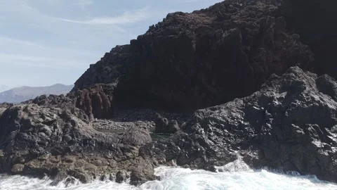 Massive waves pounding volcanic rocks, creating explosive white foam along 스톡 동영상 308396439