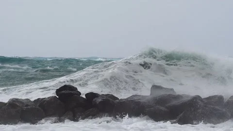 Massive waves spash over wavebreaker Stock Footage 188439631