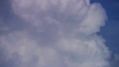 Massive white billowing clouds move slowly against blue sky Video stock 329757947