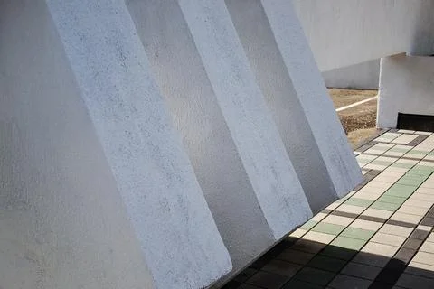 Massive white concrete structural pillars casting rhythmic geometric shadows on Fotos de archivo