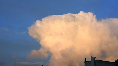 Massive white cumulus cloud rising dramatically into a clear blue sky during Stock Footage 336939490