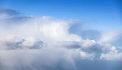 Massive white cumulus clouds in blue sky Stock Photos