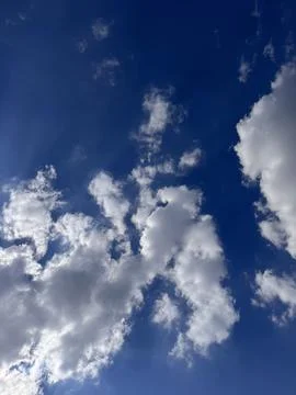 Massive white fluffy clouds and a blue sky Stock Photos