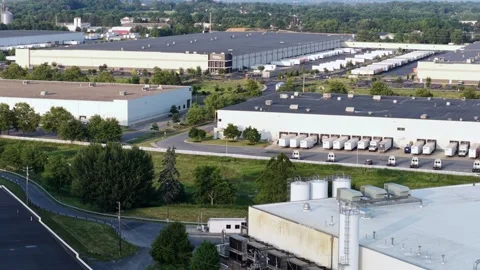 Massive white warehouses span industrial park with loading docks lined by Stock Footage 340970476