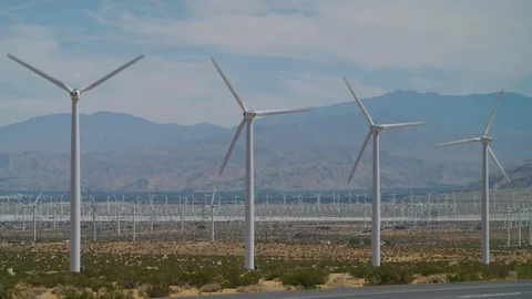 Massive wind turbines spin on windy day at the San Gorgonio Pass WindFarm Stock Footage 113300495