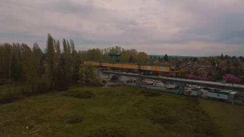 Massive yellow gantry crane constructing elevated transit guideway reversing Stock Footage 334798778