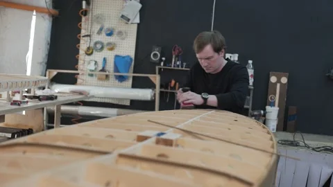 Master aligns the edge of the surf Board Stock Footage 132348373