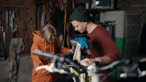 Master and Apprentice: Fixing a Bicycle Wheel in the Garage Stock Footage 240382702