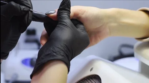 The master applies and distributes a special tool on the nail. Vídeo Stock 167919321