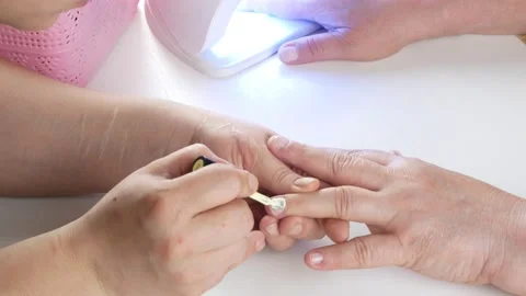 The master applies the first color layer to the nails. Vídeos de archivo 140114929