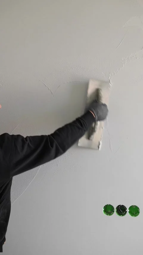 Master  applies gray decorative plaster to the wall with a spatula and trowel Video stock 317409488
