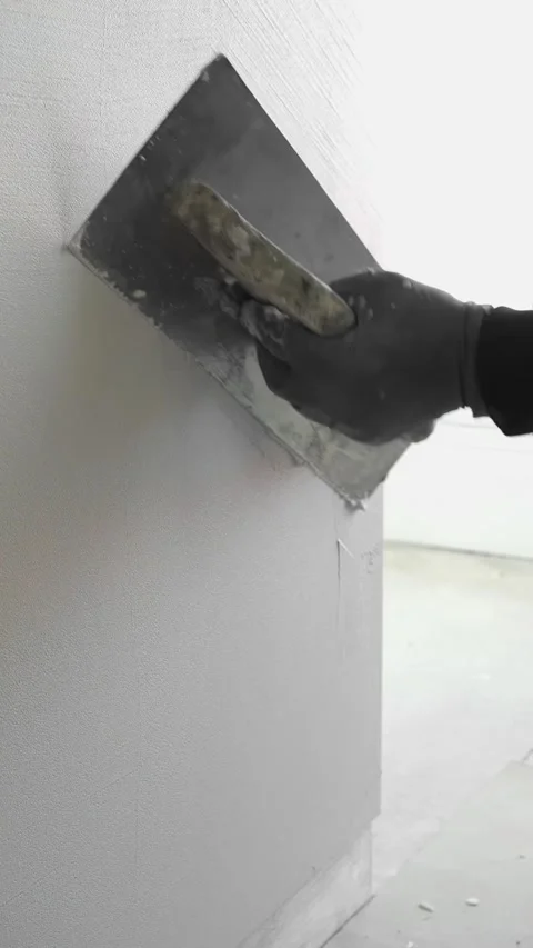 Master applies gray decorative plaster to the wall with a spatula and trowel Video stock 317409513