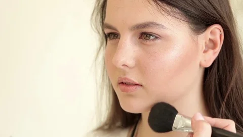 Master applies powder to model's face Stock Footage 73969634