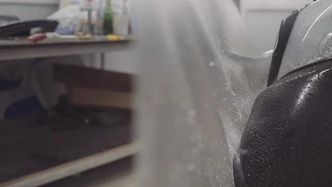 The master applies a protective layer on the surface of the car Stock Footage 93604130