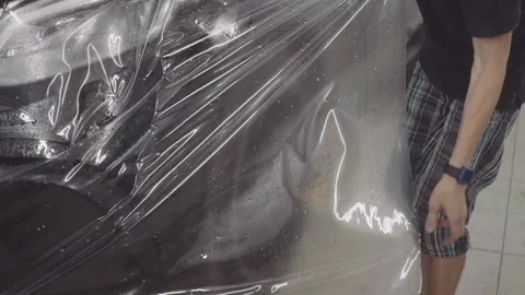 The master applies a protective layer on the surface of the car Stock Footage 93604221