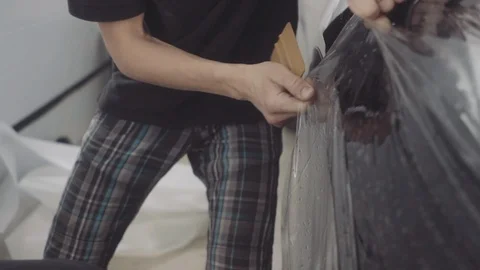 The master applies a protective layer on the surface of the car Stock Footage 93604532