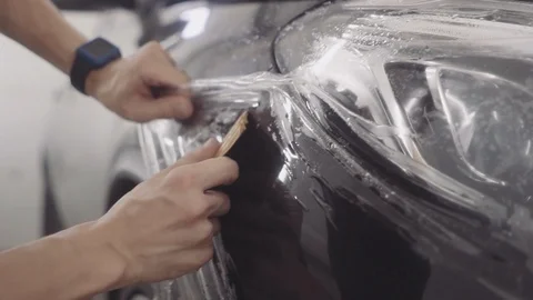 The master applies a protective layer on the surface of the car Stock Footage 93604556