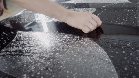 The master applies a protective layer on the surface of the car Stock Footage 93621309