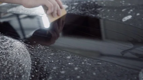 The master applies a protective layer on the surface of the car Stock Footage 93621399