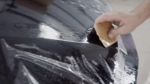 The master applies a protective layer on the surface of the car Stock Footage 93621727