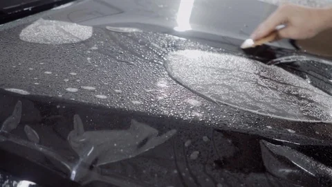 The master applies a protective layer on the surface of the car Stock Footage 93621856